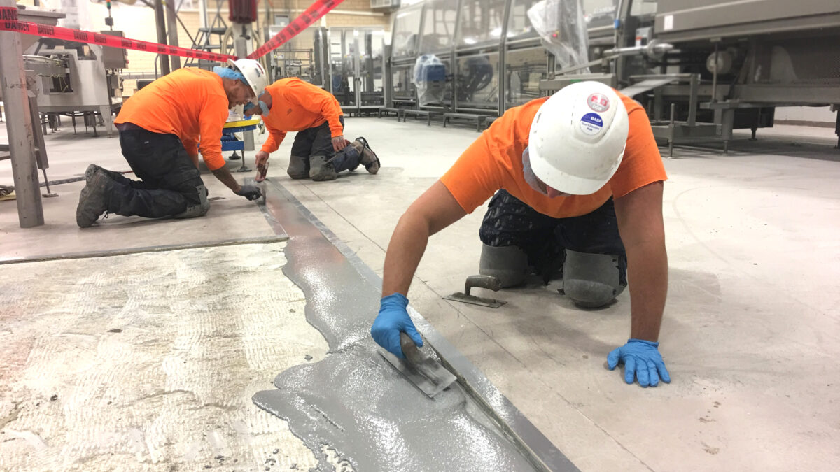 People applying epoxy floor repair in industrial facility serving Michigan, Ohio and Indiana