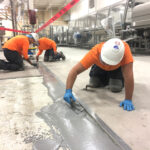 People applying epoxy floor repair in industrial facility serving Michigan, Ohio and Indiana