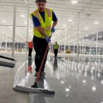 Crew installing epoxy floor coating in large warehouse serving Michigan, Ohio and Indiana