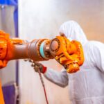 A person in white hazmat suit painting a machine in Ohio