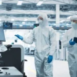 Two men working in a factory wearing hazmat suits in Michigan & Ohio