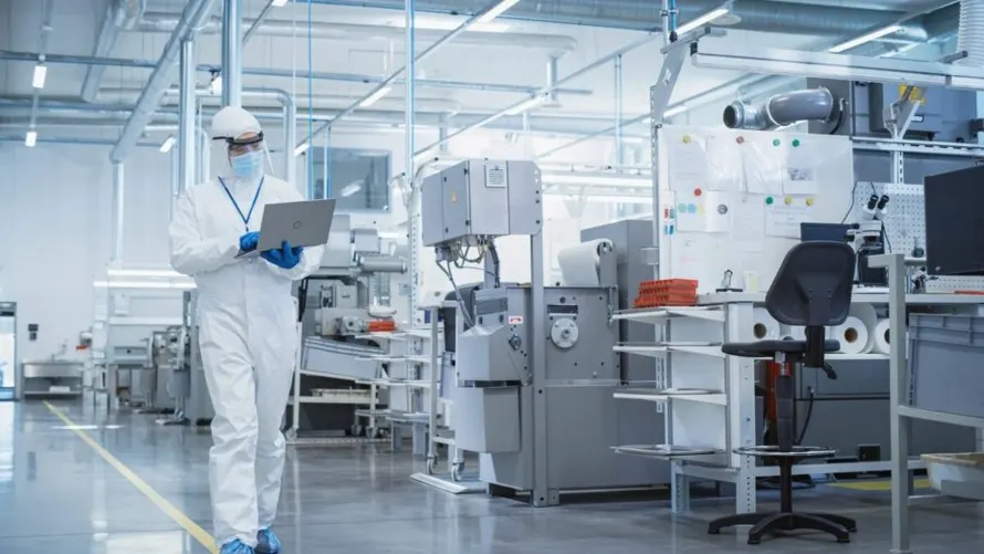 A person in white protective gear working in a factory in Michigan & Ohio