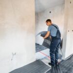 A Technician in overalls installs new flooring in a home in Saint Clair, MI