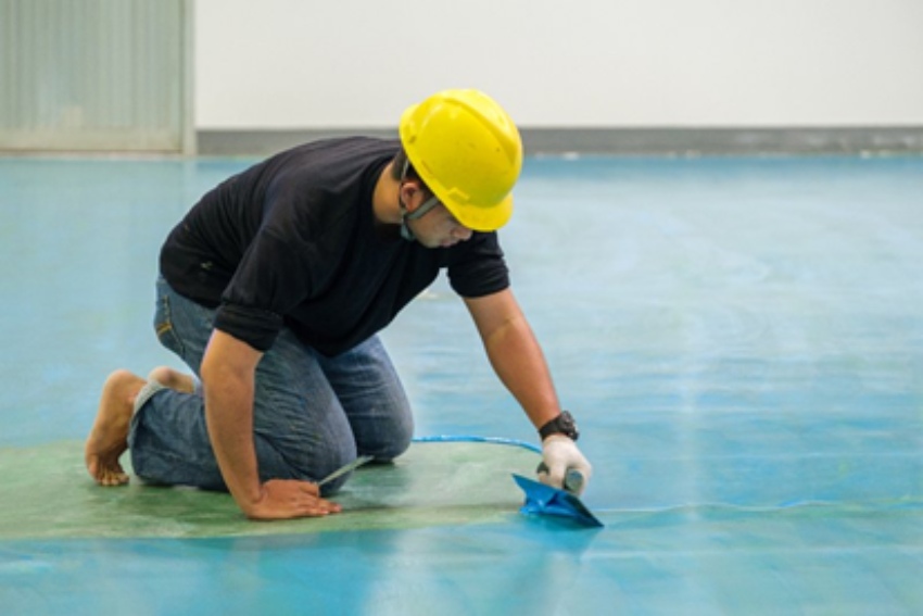Individual working with epoxy flooring in Grand Rapids