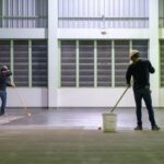 Construction worker using rollor spreading epoxy primer for Self-leveling method of epoxy floor finishing work